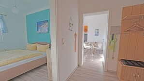 Ein Schlafzimmer mit Bett, Kleiderschrank und einem durchgegangenen Tür sichtbaren Badezimmer.