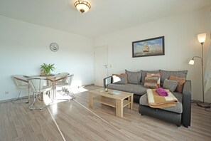 Uma sala moderna com sofá, mesa de centro e área de jantar.