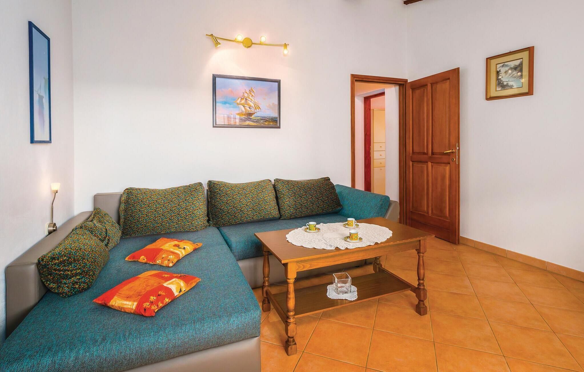 Una sala de estar acogedora con un sofá, una mesa de centro de madera y un cuadro en la pared.