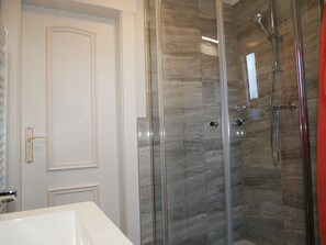 Regadera, secadora de cabello, toallas, papel de baño 