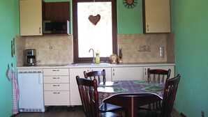 A compact kitchen with a dining table, chairs, a microwave, and a sink. - 2 bedroom lovely home in Glowczyce (Glowczyce)