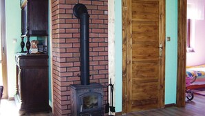 A room with a brick fireplace, a wooden door, and a wooden cabinet. - 2 bedroom lovely home in Glowczyce (Glowczyce)
