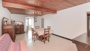 A dining area with a wooden table and chairs, a wooden cabinet, and a bench.