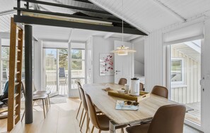 Enjoy meals in this dining area with a large table for four, a high ceiling, and a balcony with a view.