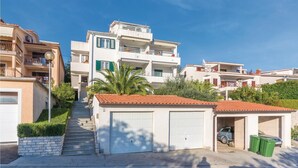 A residential building with a central staircase, two garage doors, and a satellite dish. - Beach front apartment in Rabac with WiFi (Rabac)