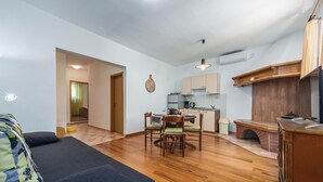 A compact living space with a dining area, kitchenette, and a cozy seating area. - Beach front apartment in Rabac with WiFi (Rabac)