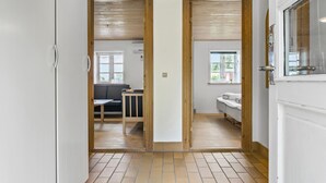 A hallway leading to a bedroom with a bed, a window, and a small table. - 3 bedroom nice home in Brovst (Brovst)