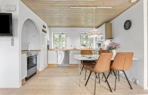 Enjoy cooking in this well-equipped kitchen with oven, microwave, and sink, and dine at the adjacent table.