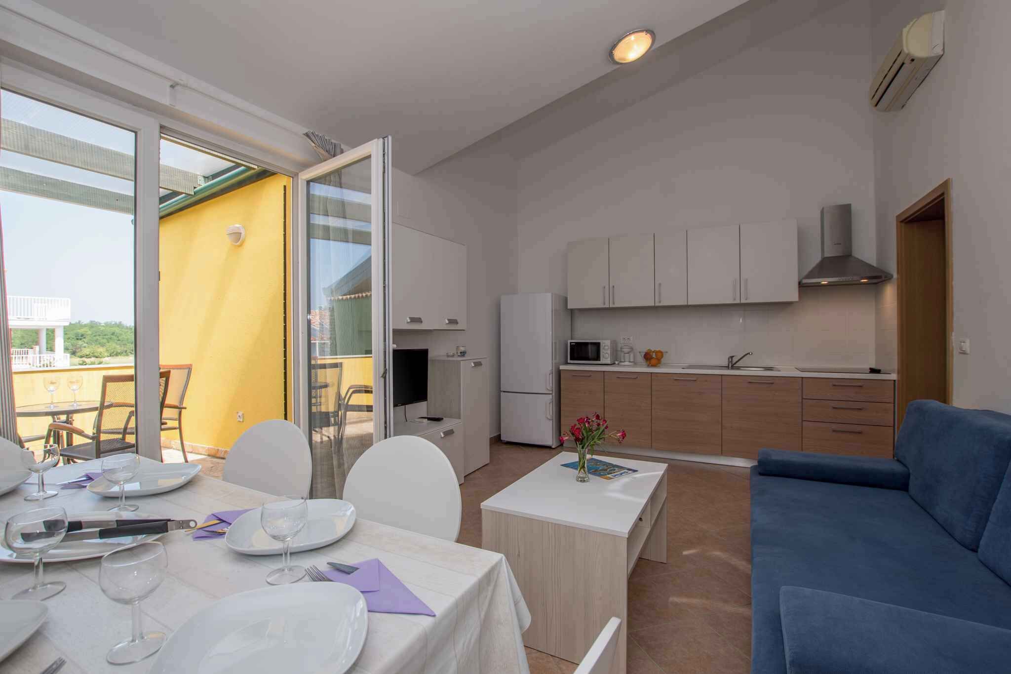 Un espace de vie compact comprenant un coin repas, une kitchenette et un canapé.