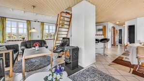 Un salon moderne doté d’une cheminée, d’un coin repas et d’un escalier menant à un niveau supérieur.