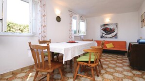 Un comedor con una mesa, sillas, un sofá y un cuadro en la pared.