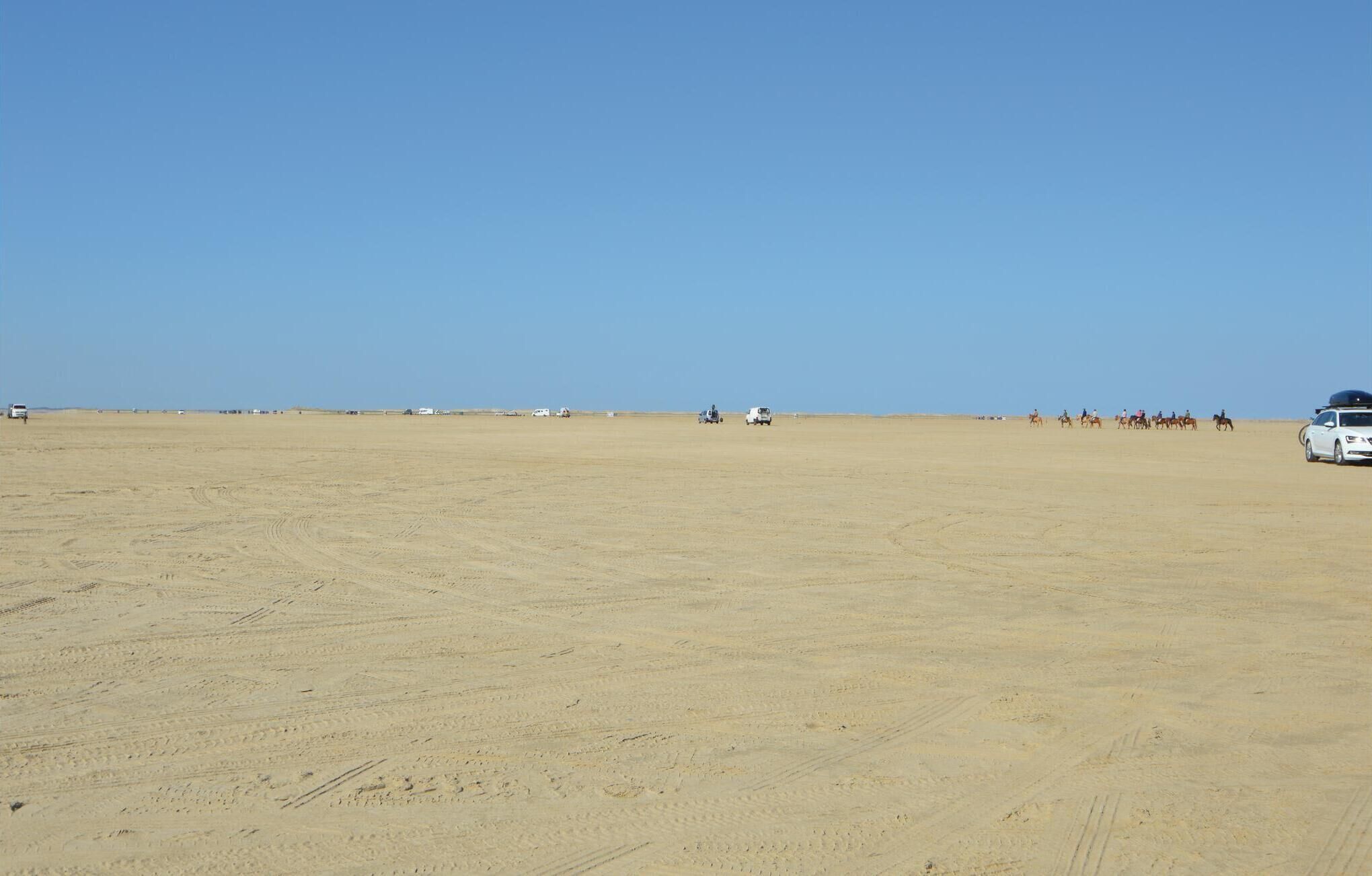 A vast, open desert landscape with a clear blue sky.