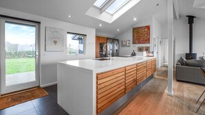 A modern kitchen with a large island, wooden cabinets, and a skylight. - 3 bedroom amazing home in Slagelse (Slagelse)