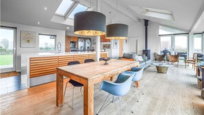 A modern kitchen with a central island, wooden cabinetry, and pendant lighting. - 3 bedroom amazing home in Slagelse (Slagelse)