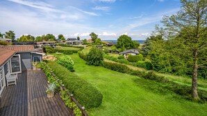 A residential area with houses, a wooden deck, and a well-maintained lawn.
