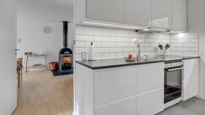 A modern kitchen with white cabinetry, a built-in stove, and a separate oven. - Gorgeous home in Aakirkeby with sauna (Aakirkeby)