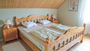 Un letto di legno con due cuscini e un comodino con una lampada.