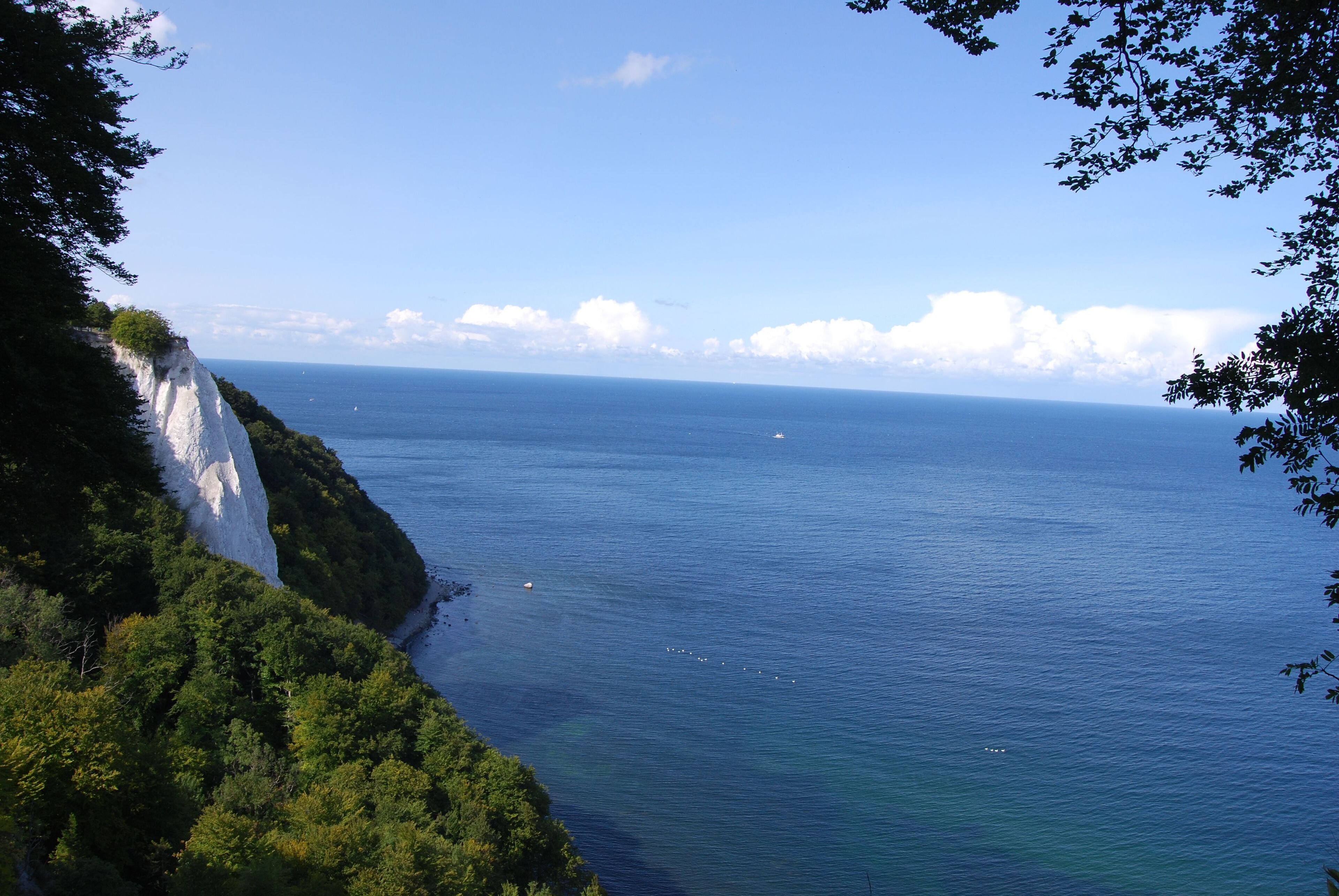 Paesaggio costiero con una scogliera e vista sul mare.