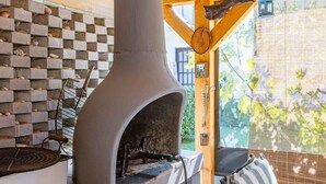 A stone oven with a chimney, a checkered wall, and a view of greenery outside. - Studio with balcony and air conditioning (Malinska)