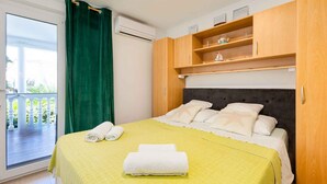 A hotel room with a bed, a balcony, and a wooden wardrobe. - Studio with balcony and air conditioning (Malinska)