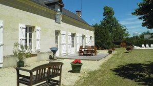 Un bâtiment doté d’un patio couvert, d’un espace extérieur aménagé pour s’asseoir et d’une pelouse.