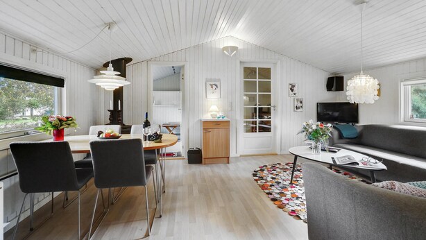 En modern inredning med matplats, kök och vardagsrum.