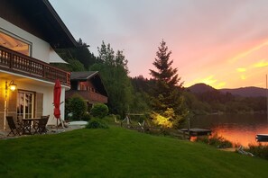 Una propiedad frente al lago con comedor, terraza y vistas al lago y las montañas.