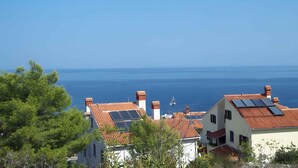Zona residencial costera con casas de techos rojos y paneles solares.