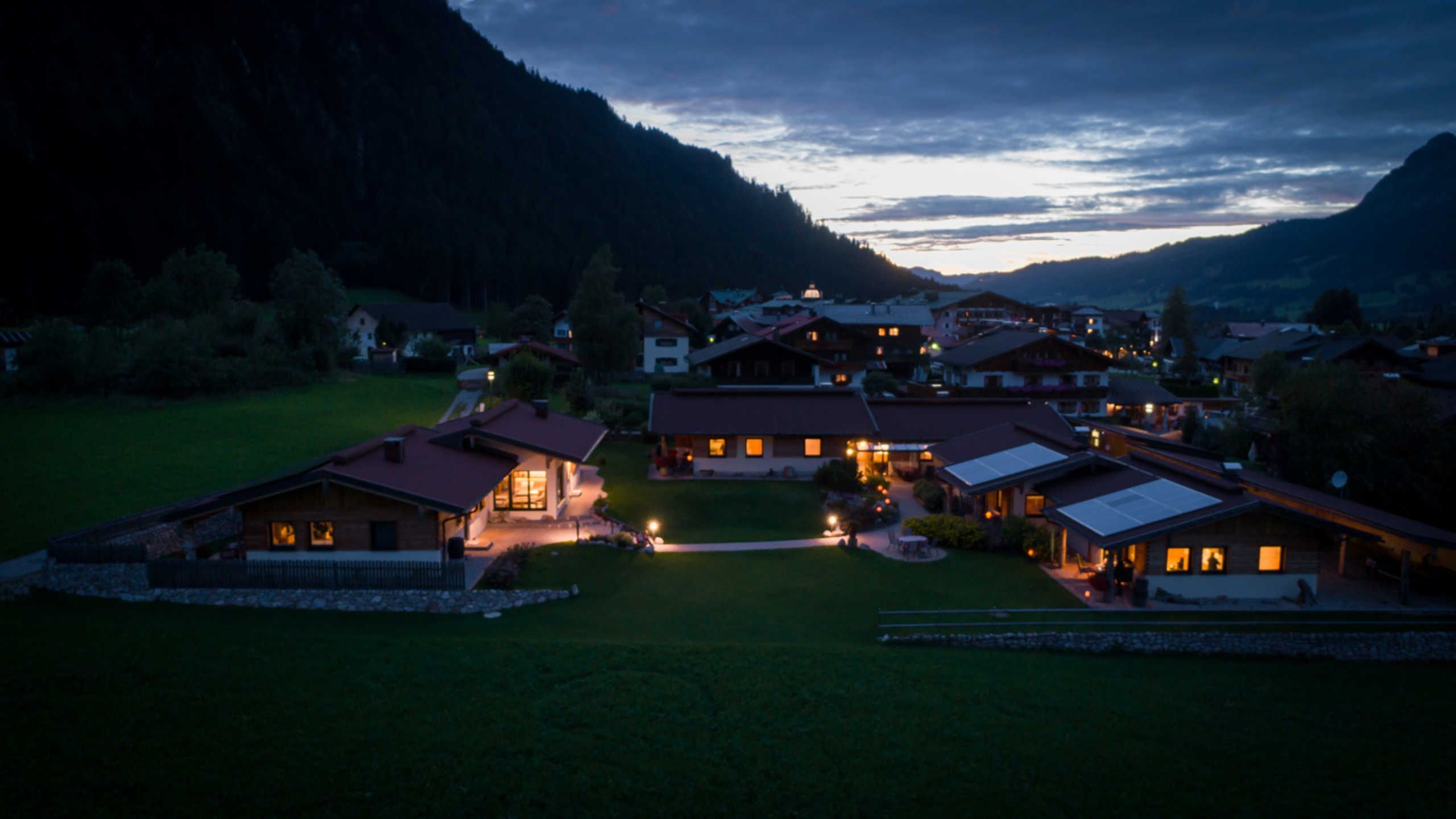 A rural village with traditional houses, a central open space, and surrounding hills.