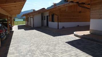 Un espacio al aire libre techado con un camino empedrado que lleva a una hilera de edificios de madera.