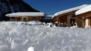 A snow-covered building with a wooden facade and a sloped roof.