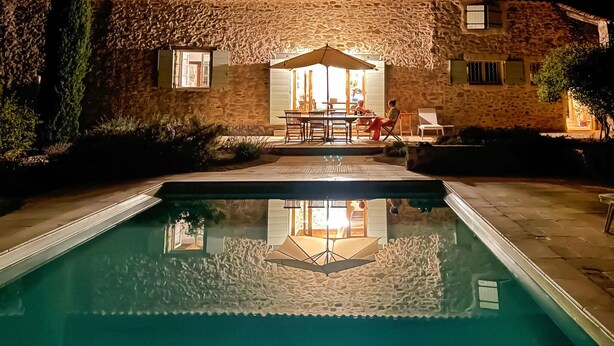 Un bâtiment en pierre doté d’une piscine, d’un espace extérieur aménagé et offrant une vue sur l’intérieur.