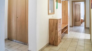 A hallway with wooden wardrobes, a mirror, and a wooden cabinet.