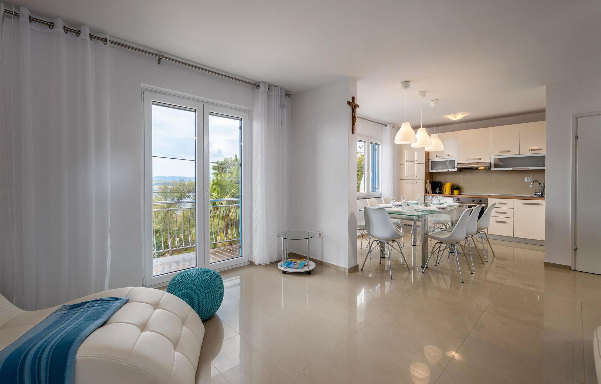 A modern apartment with a balcony, a dining area, and a kitchen.