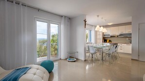 Un appartement moderne doté d’un balcon, d’un coin repas et d’une cuisine.