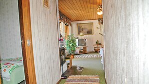 A narrow hallway leading to a living area with a television, a plant, and a dining table. - 3 bedroom gorgeous home in Svanesund (Svanesund)