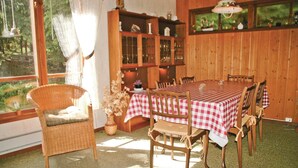 A dining area with a checkered tablecloth, wicker chairs, and a cabinet with glass doors. - 3 bedroom gorgeous home in Svanesund (Svanesund)