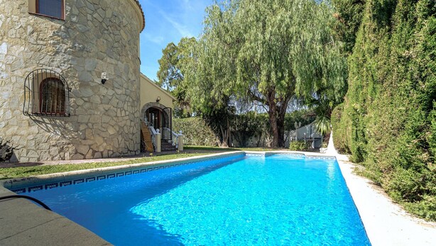 A swimming pool with a stone building and a tree-lined background. - Pet friendly home in Els Poblets (Els Poblets)