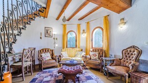 A cozy living room with a wooden staircase, leather armchairs, a patterned rug, and a dining table. - Pet friendly home in Els Poblets (Els Poblets)