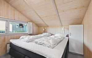 Ein Schlafzimmer mit einem Bett, einem Fenster und einem weißen Kleiderschrank.