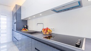 A modern kitchen with a black countertop, stainless steel appliances, and a fruit bowl. - Gorgeous home in Malinska (Malinska)