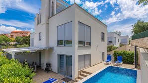 A modern two-story house with a swimming pool, a covered patio, and a view of the surrounding neighborhood. - Gorgeous home in Malinska (Malinska)
