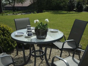 A round table with chairs, a potted plant, and matching cups and plates. - Vacation apartment Meer, Germany (Hasselberg)