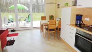 A kitchen with a dining area, a coffee machine, and a view of the outdoors.