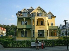 A multi-story building with a yellow facade and a sign that reads "Villa Luminis." - (213) 2-room apartment - apartment house Villa Laura (Kühlungsborn)