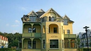 A multi-story building with a yellow facade and a sign that reads "Villa Luminis." - (213) 2-room apartment - apartment house Villa Laura (Kühlungsborn)