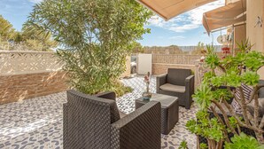 An outdoor patio with wicker furniture, a decorative vase, and various plants. - Stunning apartment in Torrevieja (Torrevieja)