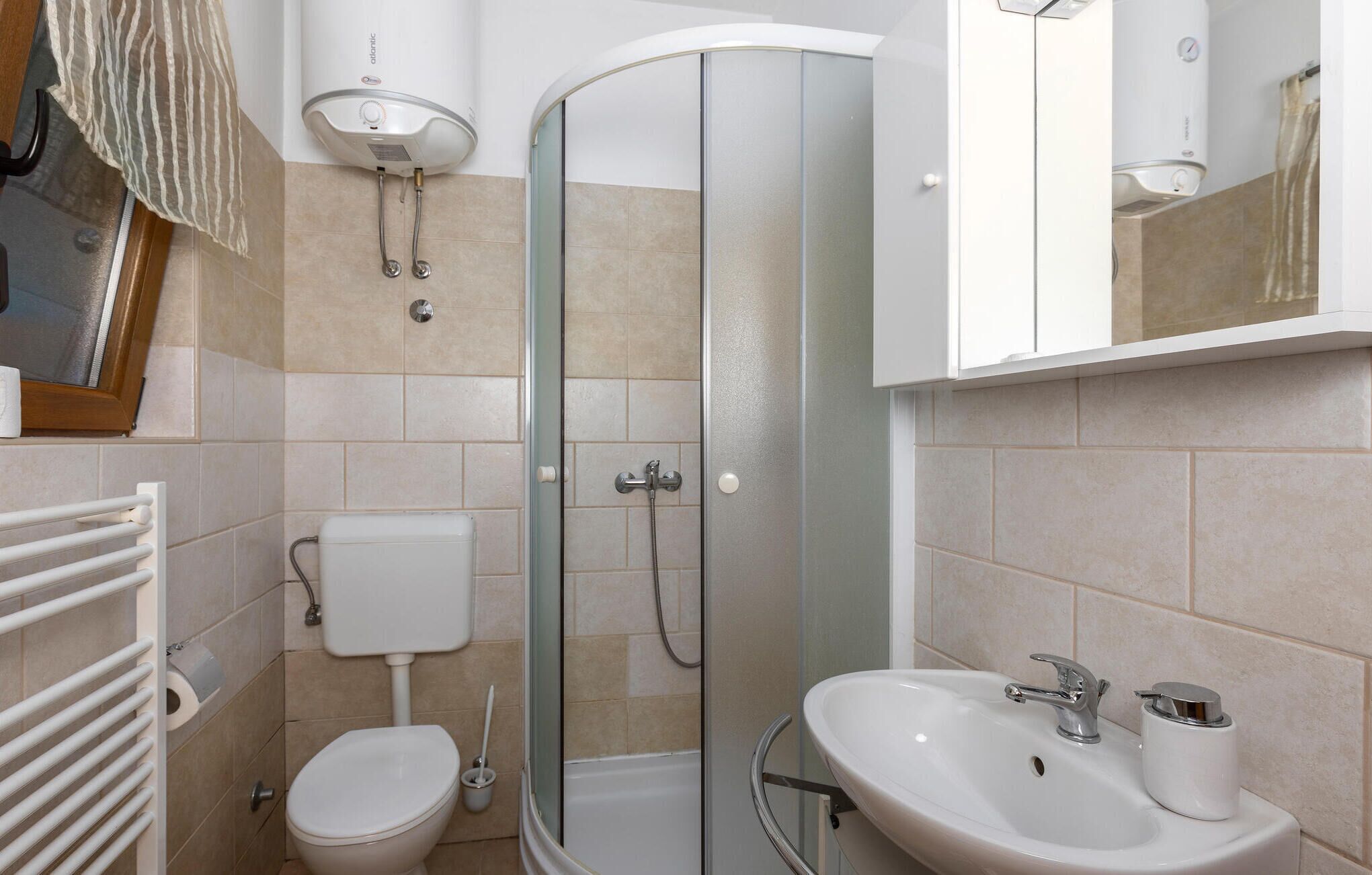 Une salle de bain avec des toilettes, une douche et un lavabo.