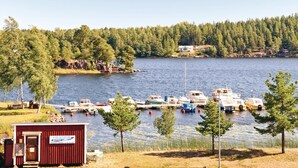 Ein Yachthafen mit mehreren anglegerten Booten, umgeben von bewaldetem Gebiet und einem kleinen Gebäude mit der Aufschrift "HUGES MARINA".