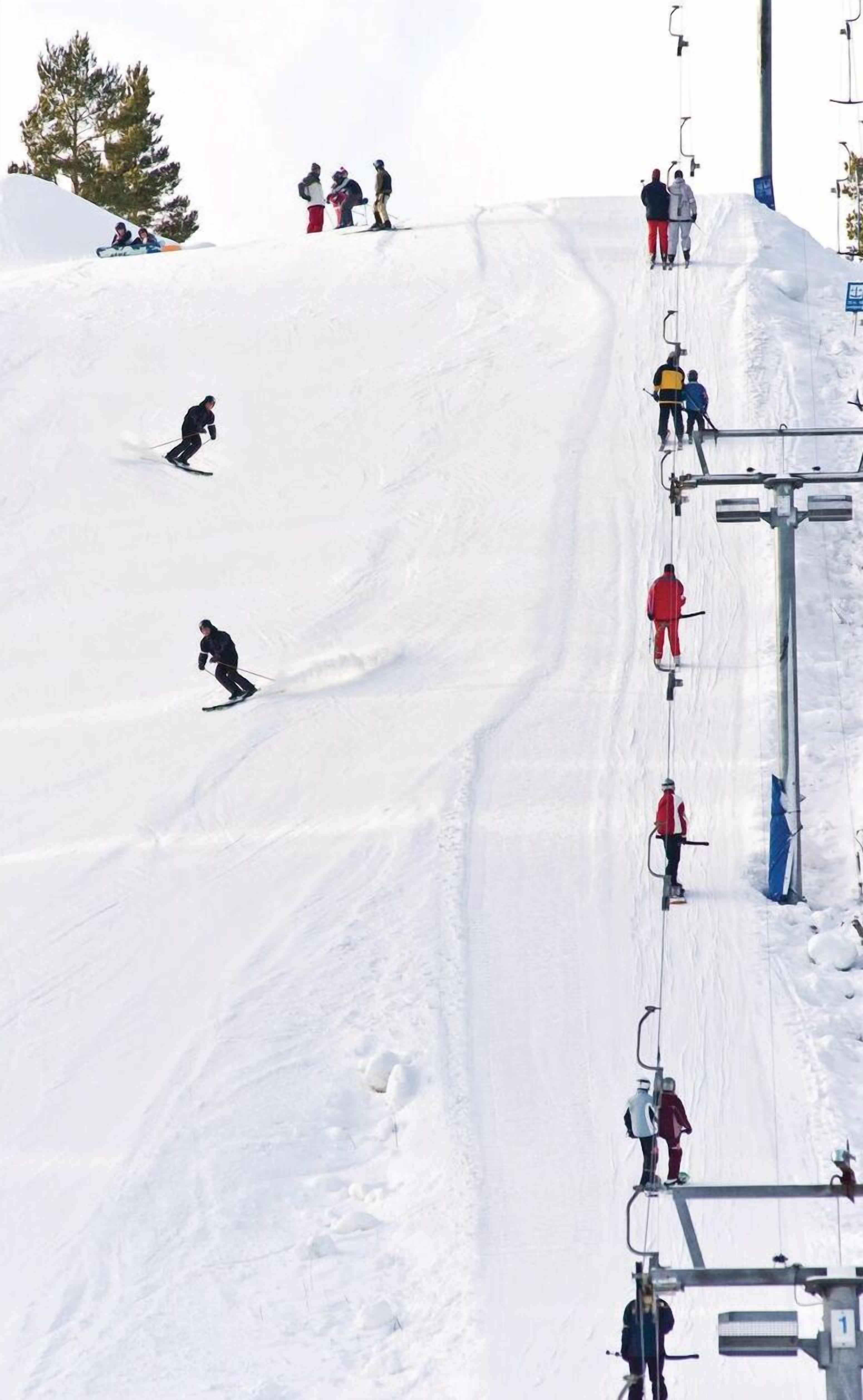 A ski slope with skiers and a ski lift.